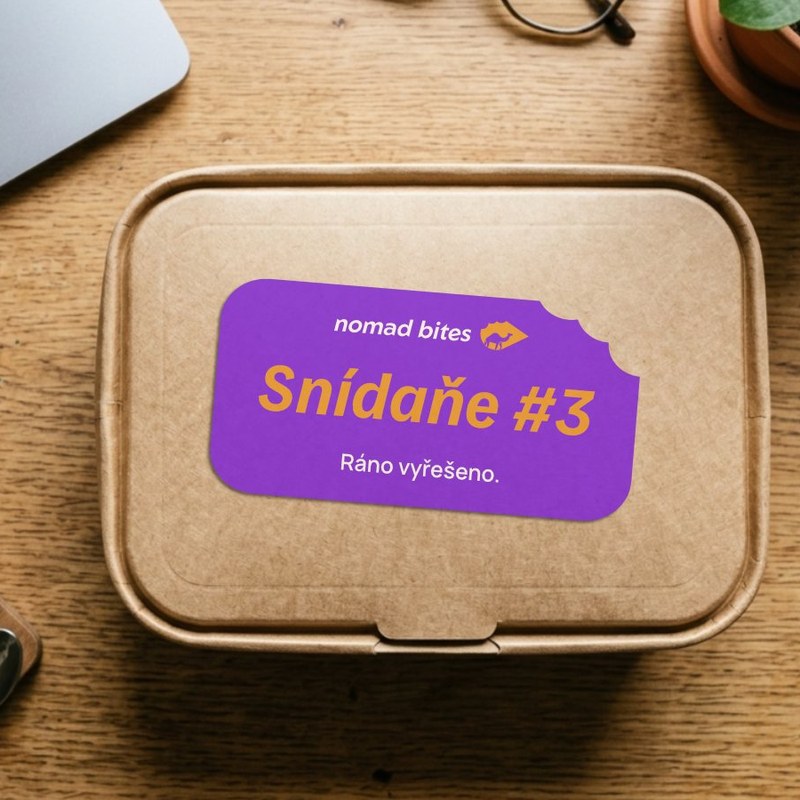 Krabička Nomad Bites se samolepkou Snídaně #3 na pracovním stole, projekt vizuální identity